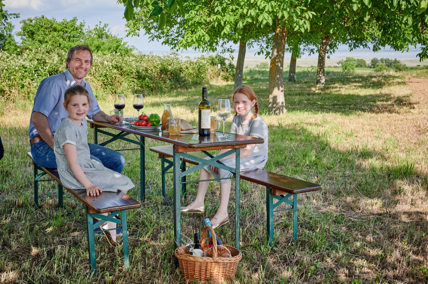 Familie beim Weinpicknick am gedeckten Tisch