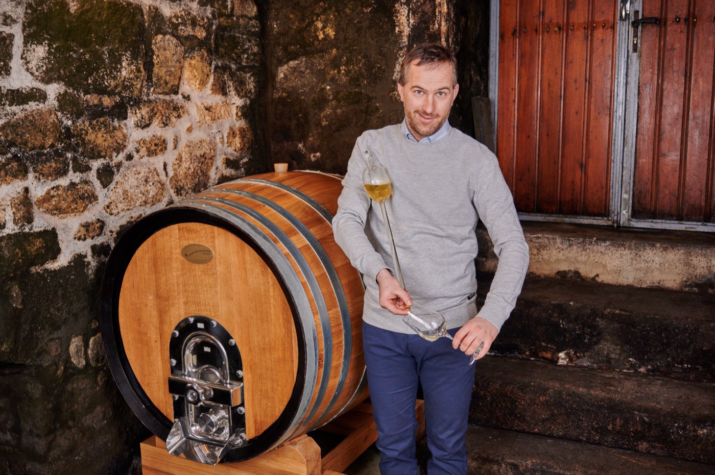 Der Winzer mit einem Glas Weißwein