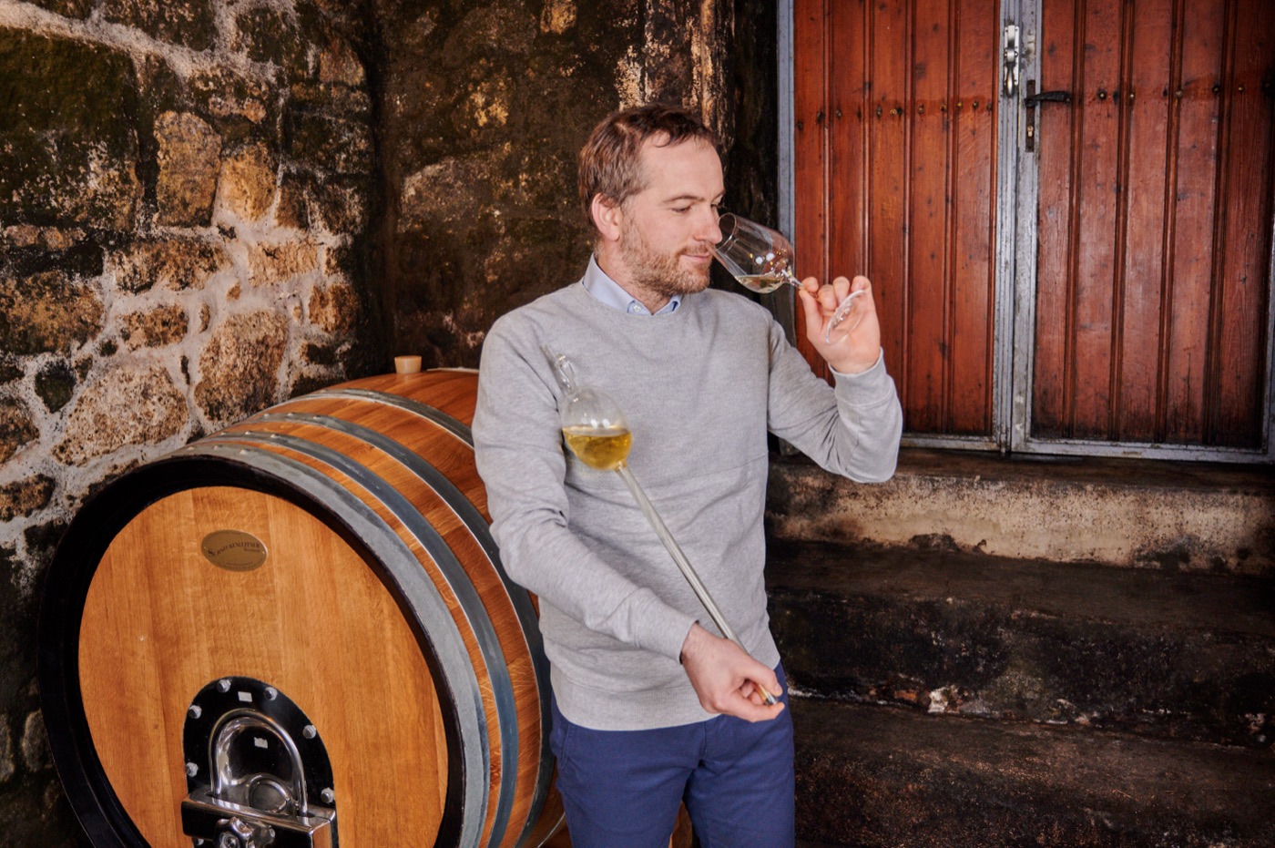 Winzer Artner verkostet einen Wein aus dem Fass